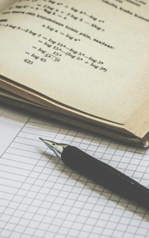 pexels photo 167682 167682 Mathematical study scene with open book, graph paper, and pen for learning and homework.