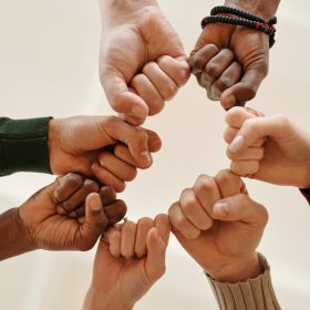 pexels photo 6146704 6146704 Hands of diverse people fist bumping, symbolizing unity and teamwork.